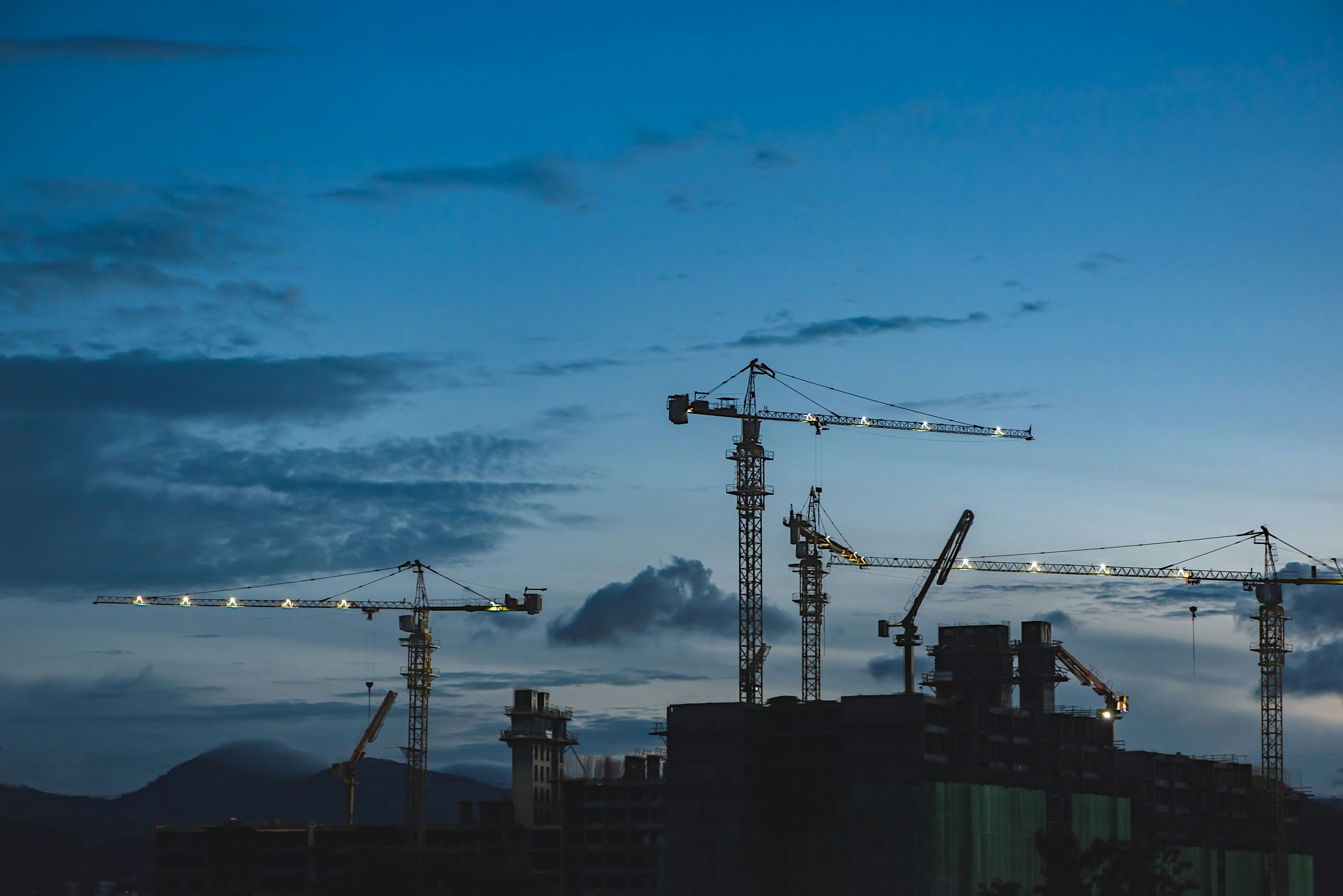 Tower cranes on a construction site at dusk